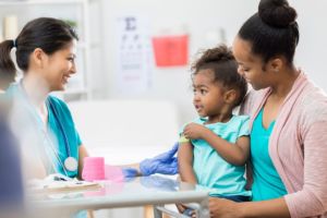 Mother taking daughter to see nurse