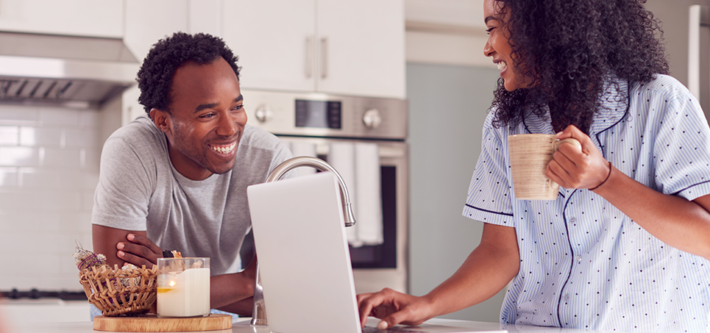 Young couple in pajamas using laptop