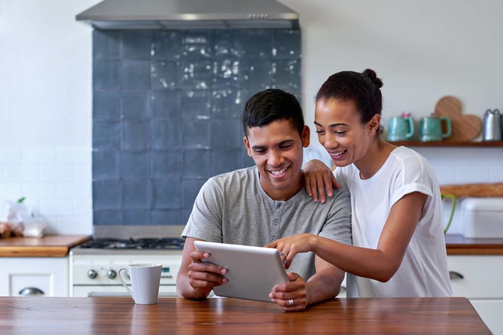 Young couple looking at laptop in the kitchen