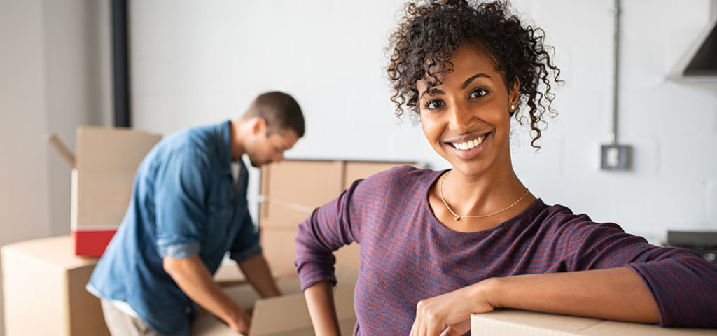 Happy couple moving into a new apartment with boxes