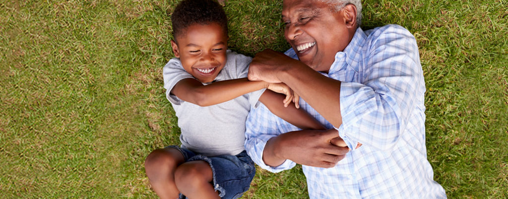 Grandfather and grandson playing in the grass