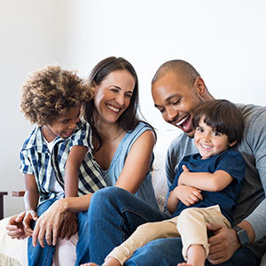 Family of four laughing on the couch