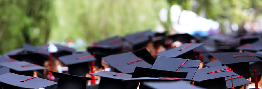 Group of high school graduates wearing cap and gown.