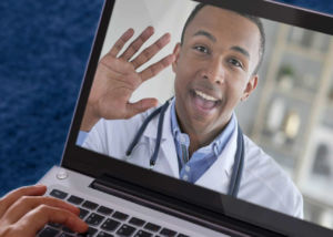 Waving telemedicine doctor on laptop screen