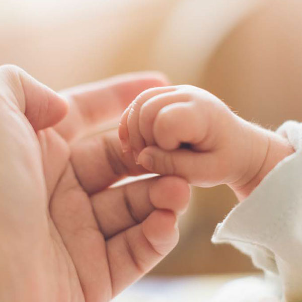Mano de bebé sosteniendo el dedo de la madre