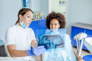 Dental worker showing X-rays to patient