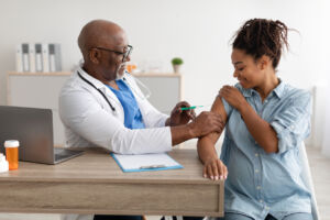 Smiling Pregnant Woman Getting Vaccinated In Doctor's Office