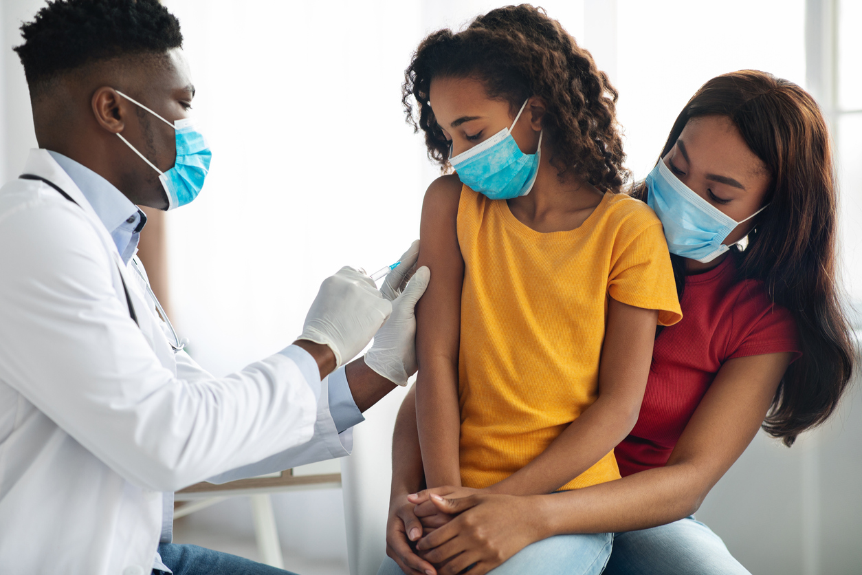 doctor making vaccination in shoulder for child