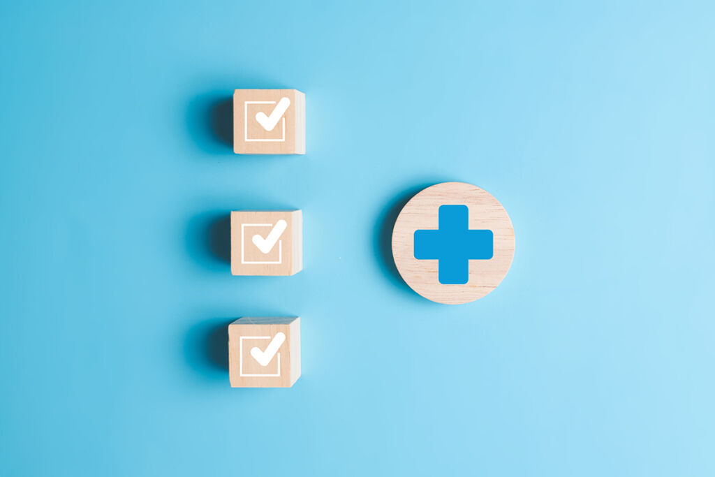 Plus and check mark icons on wooden blocks for medical and health care concept, Access to welfare health, People with health care, Health insurance, Family life insurance, Medical care insurance